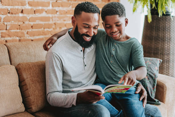 istock Father reading a book with son toddler boy 1542692666