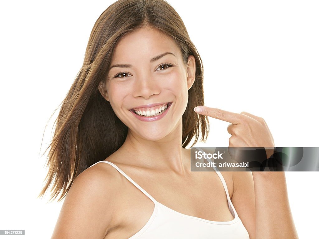 Dental teeth - perfect smile woman Dental teeth - perfect smile woman pointing at toothy smile looking happy at camera. Dental teeth concept photo with mixed race asian caucasian female model isolated on white background. One Woman Only Stock Photo