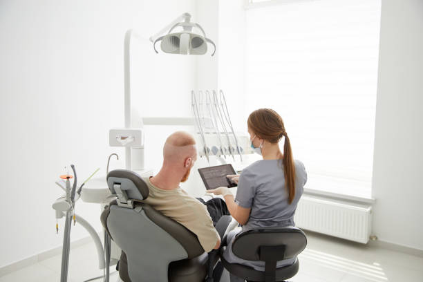 retrato de una joven dentista de pie junto a un hombre adulto en la clínica. dentista hembra reparando diente de paciente en ambulant dental - ambulant patient fotografías e imágenes de stock