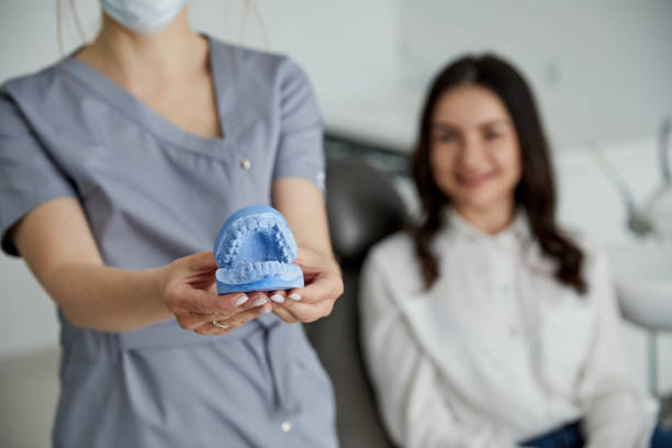 portrait of young female dentist standing by mid adult woman in clinic. female dentist repairing patient tooth in dental ambulant - ambulant patient imagens e fotografias de stock