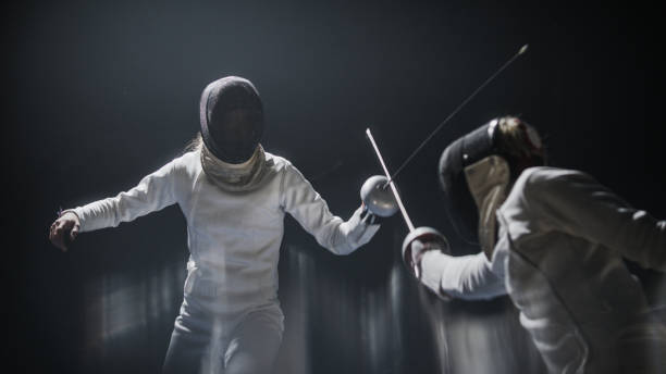 istock Two professional fencers foil swords facing each other in combat. Parrying a hit 1542720652
