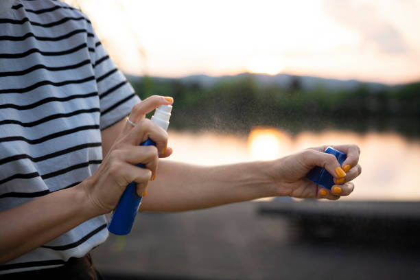 istock A woman applies mosquito spray. 1542721711
