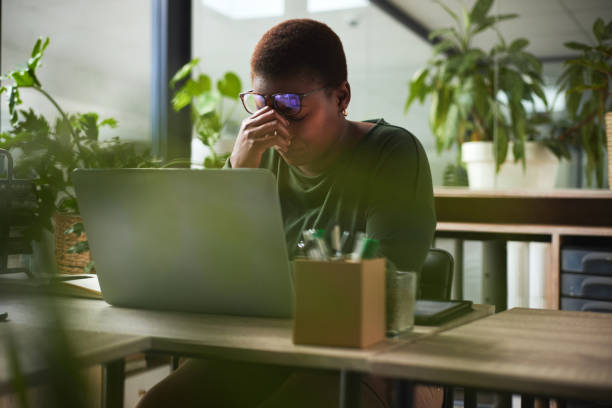 Headache, pain and business woman on computer editing report, online mistake or problem in startup office. Stress, fatigue and glasses of editor or person on laptop with eye care or article deadline