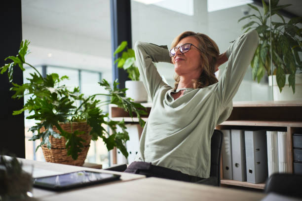 Sleep, relax and business woman finished with working on a project in office. Success, peace and calm with happy person resting after job complete, hands behind head and stretching for zen in company stock photo