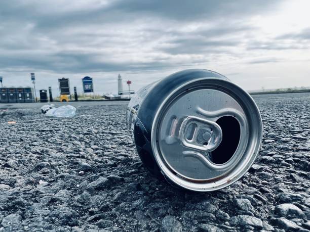 Discarded fizzy drink can against cloudscape