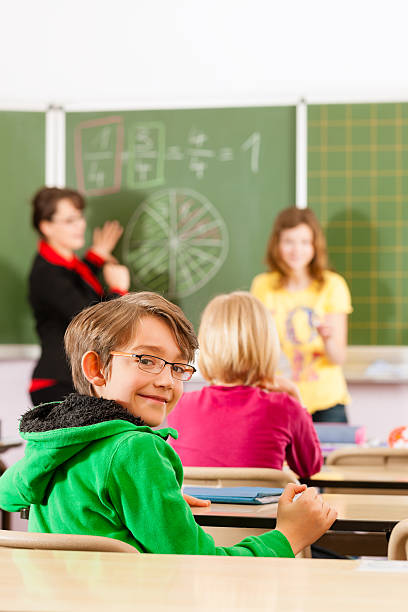 istock Education - teacher with pupil in school teaching 154277035