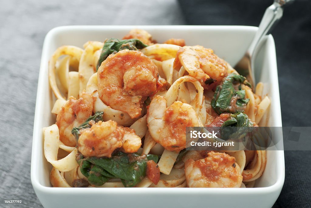 Fettuccini with Shrimp White square bowl of pasta with shrimp,  tomato sauce and spinach Carbonara Sauce Stock Photo