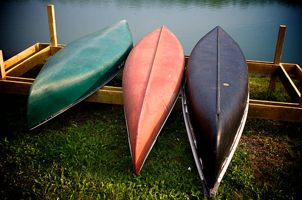 istock Three colored canoes lying by a body of water 154279874