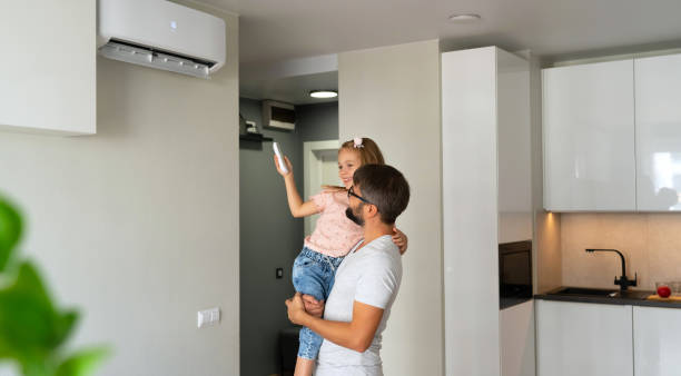 Father kept to hand daughter and turn on air conditioner using remote control Father kept to hand little daughter and turn on air conditioner using remote control. Happy family adjust comfortable temperature of cooler system air conditioner family stock pictures, royalty-free photos & images