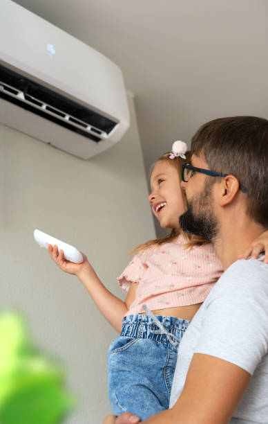 istock Family, father and daughter fun turn on air conditioner using remote control. 1542800525