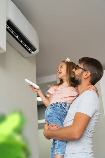 Happy family, father and girl turn on air conditioner using remote control. Happy family, father and little girl fun turn on air conditioner using remote control. Cooler system air conditioner family stock pictures, royalty-free photos & images