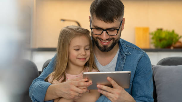 istock Father and child use tablet at home. Computer games, internet, social media 1542800531