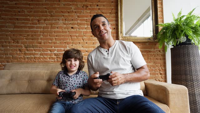 Father and son playing video games together