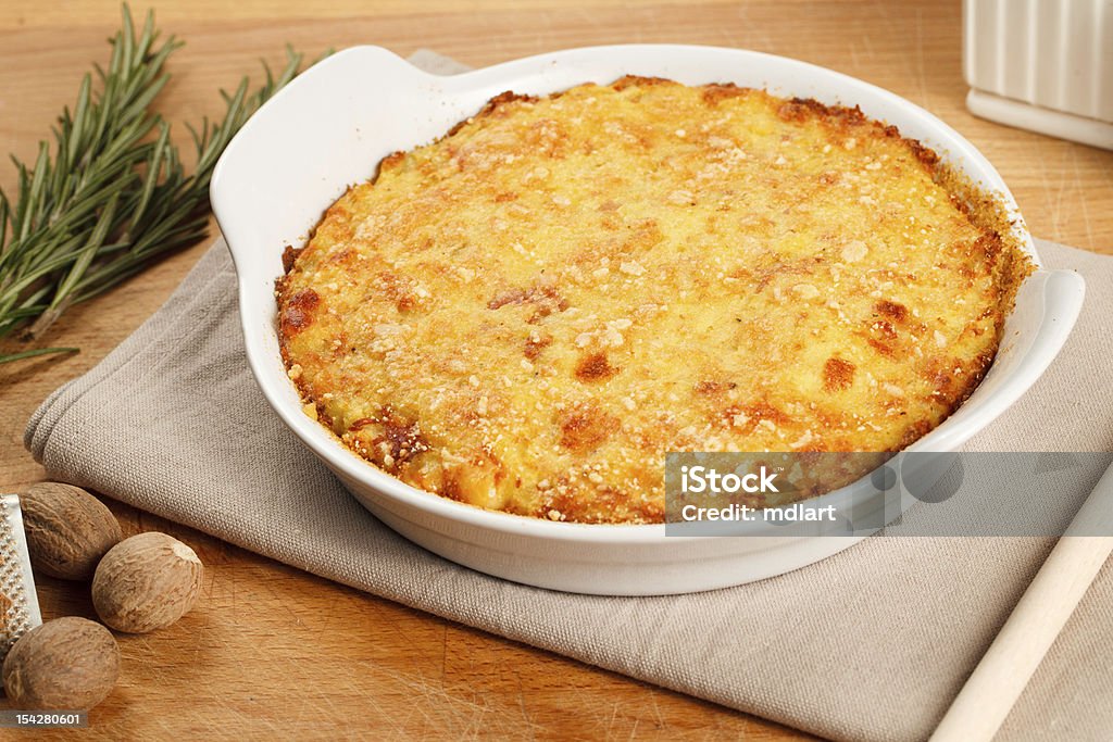 Gateau - potatoes pie Traditional gateau potatoes pie with cheese and nutmeg. Served in a terrine over a wooden board Prepared Potato Stock Photo