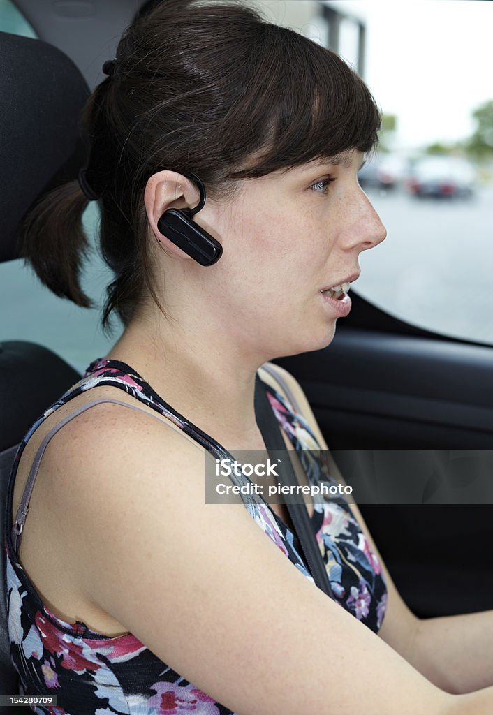 Telefone com fone de ouvido bluetooth e dirigindo carro - Foto de stock de Bluetooth royalty-free