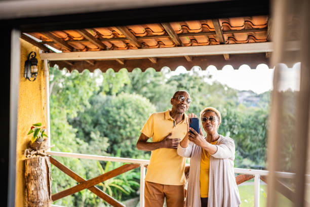 Senior couple doing a video call on mobile phone in a hotel balcony