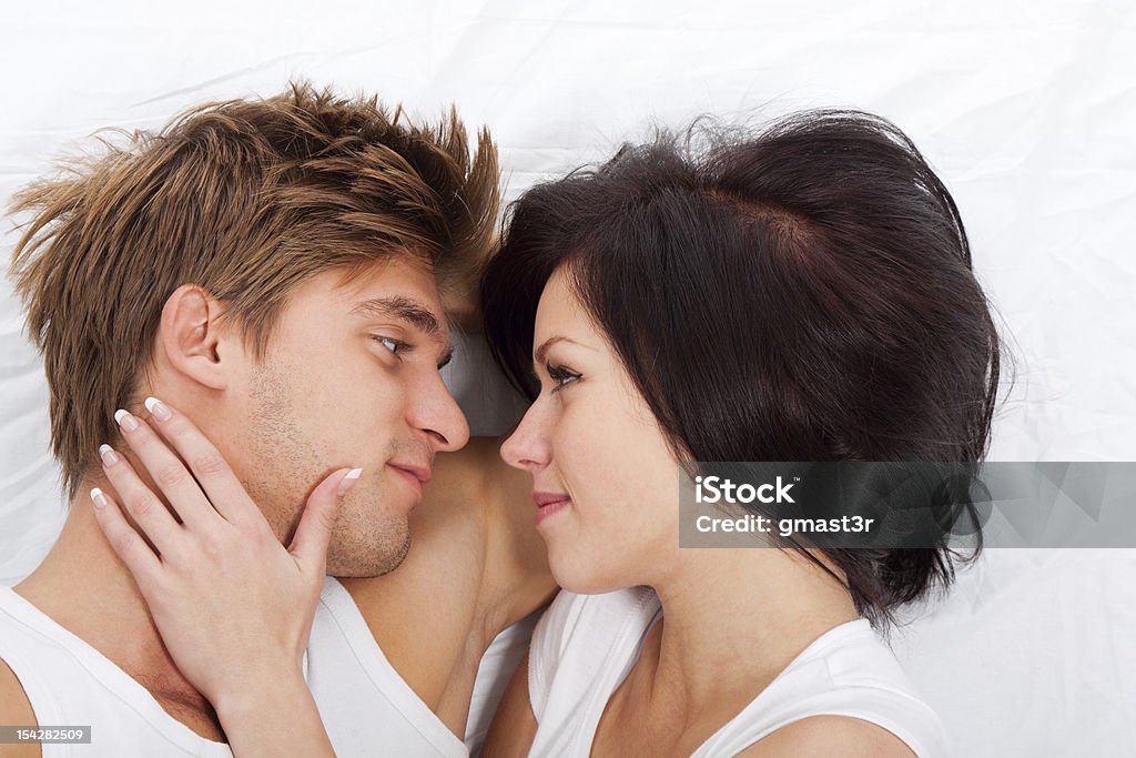 Casal Deitado na cama - Foto de stock de Abraçar royalty-free