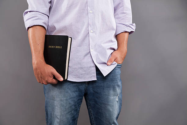 uomo casual tiene bibbia - bible stand foto e immagini stock