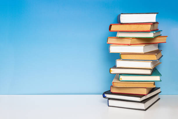 istock Composition with vintage old hardback books, diary on wooden table and blue background. Books stacking. Back to school. Copy Space. Education background. 1542854985