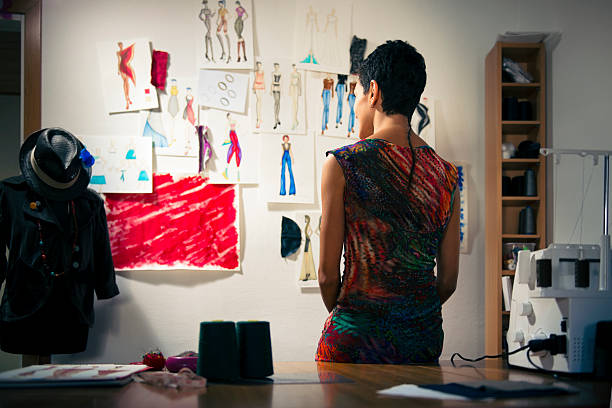 Female fashion designer contemplating drawings in studio Young people and small business, hispanic woman at work as fashion designer and tailor, looking at sketches of new collection in atelier mannequin photos stock pictures, royalty-free photos & images