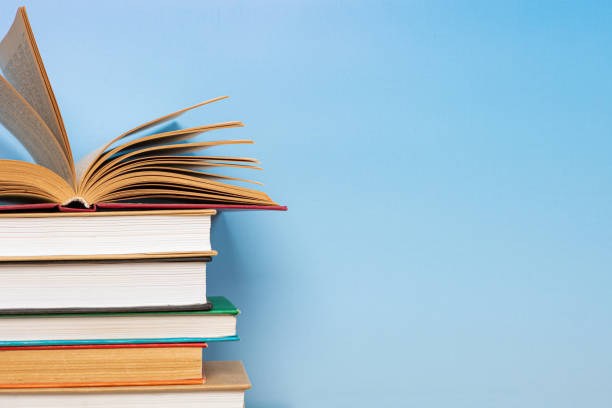 istock Composition with vintage old hardback books, diary on blue background. Books stacking. Back to school. Copy Space. Education background. 1542875875