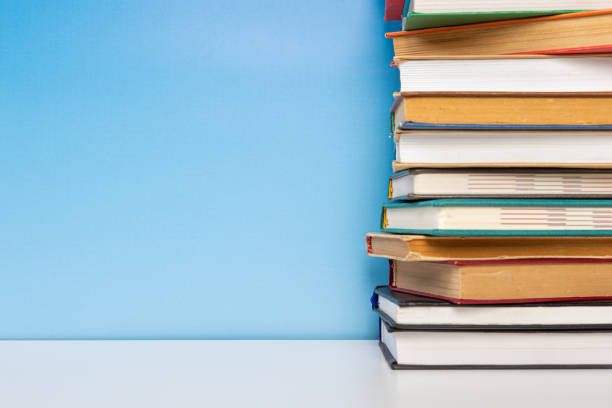 istock Composition with vintage old hardback books, diary on wooden table and blue background. Books stacking. Back to school. Copy Space. Education background. 1542876941