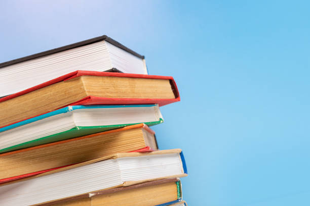 istock Composition with vintage old hardback books, diary on blue background. Books stacking. Back to school. Copy Space. Education background. 1542882172