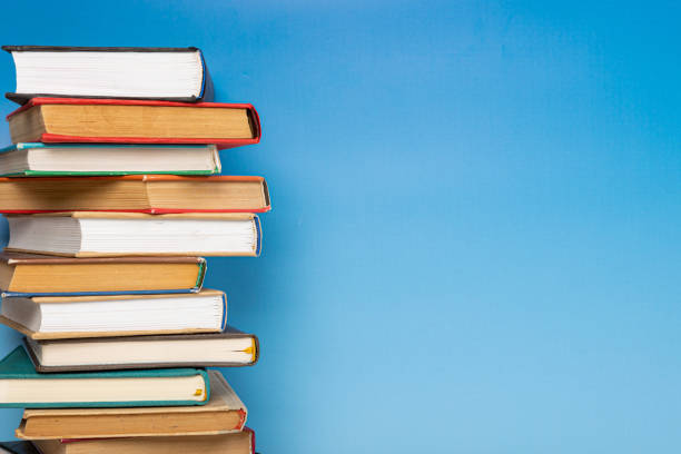istock Composition with vintage old hardback books, diary on blue background. Books stacking. Back to school. Copy Space. Education background. 1542882187