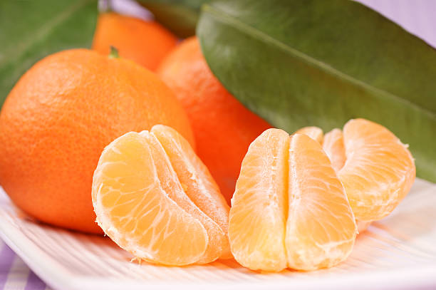 целом и сечение clementines - sectioned стоковые фото и изображения