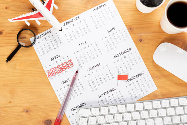 istock Calendar and reminders for work trips, travel and vacations. glider on desktop with airplane and magnifying glass pen, keyboard. mark important plans in a diary at the office desk. 2023 calendar reminder concept. 1542886495
