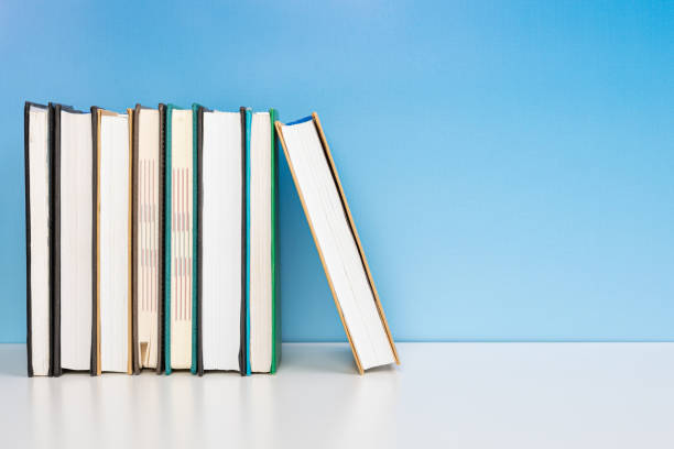 istock Composition with vintage old hardback books, diary on wooden table and blue background. Books stacking. Back to school. Copy Space. Education background. 1542886849