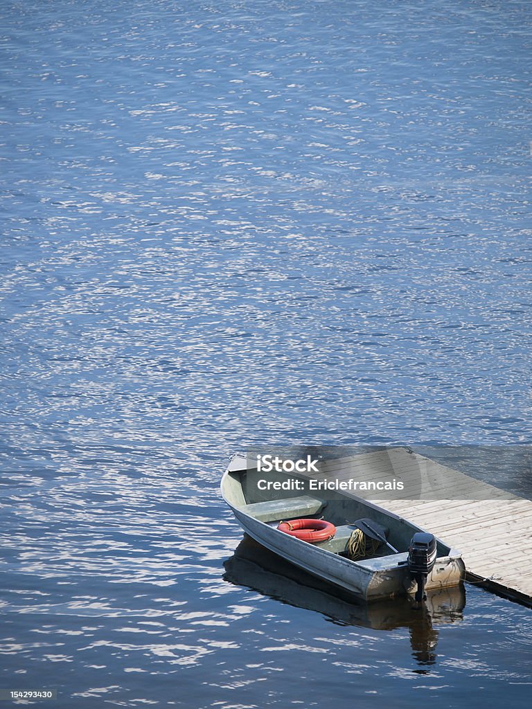 small boat waits at a wooden dock Lake Stock Photo