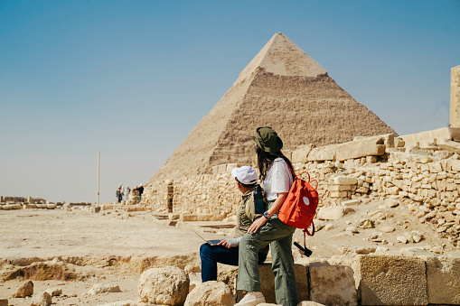 Multiracial couple working on their laptops in giza area, pyramid pharaoh, Cairo
