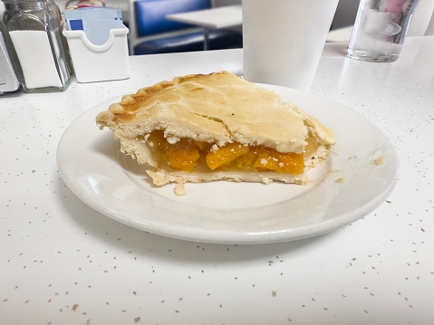 Slice of peach pie on a diner table