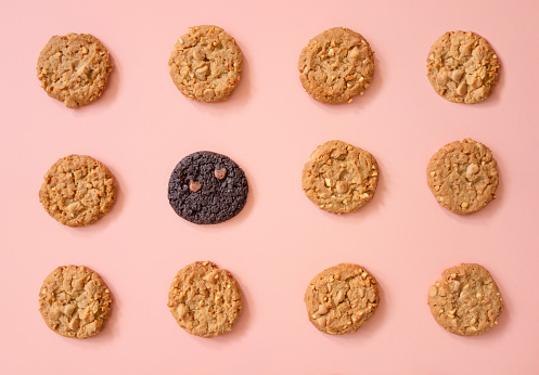 Looking down on peanut butter and chocolate cookies in a row on a pastel colored background
