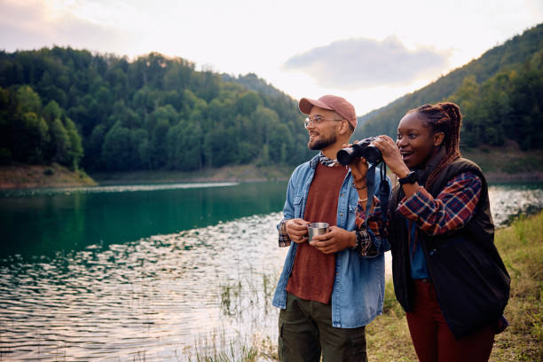 istock Happy multiracial couple exploring nature with binoculars. 1542961112