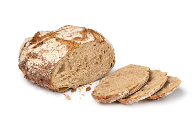 Sourdough loaf of bread with pumpkin seeds and slices close up on white background Fresh baked sourdough loaf of bread with pumpkin seeds and slices close up isolated on white background loaf of bread stock pictures, royalty-free photos & images