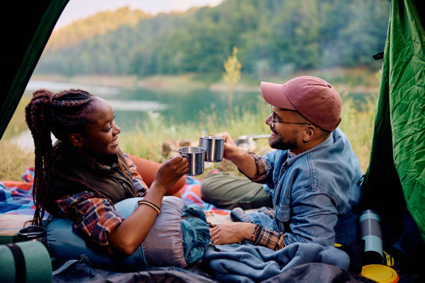 istock Happy multiethnic couple toasting while relaxing in a tent on camping. 1542964772