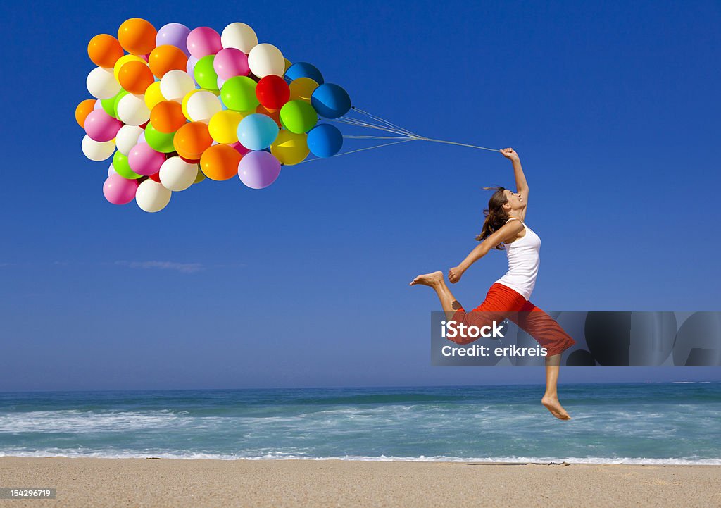 Jumping with balloons Beautiful and athletic girl running and jumping with colorful balloons on the beach 20-24 Years Stock Photo