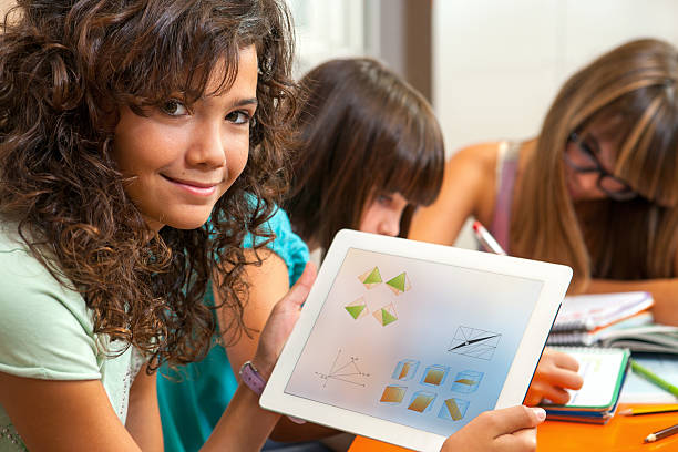 Close up portrait of cute young student holding tablet with homework.