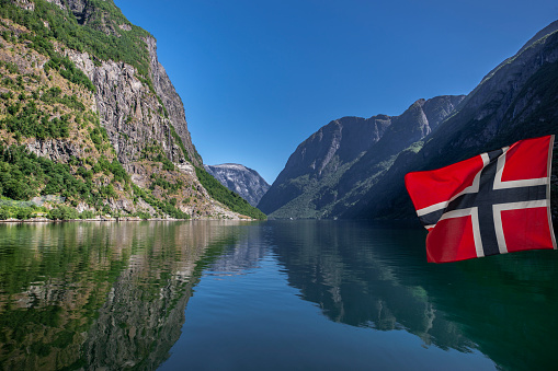 Norwegian flags reflection in Naerøyfjord in Norway
