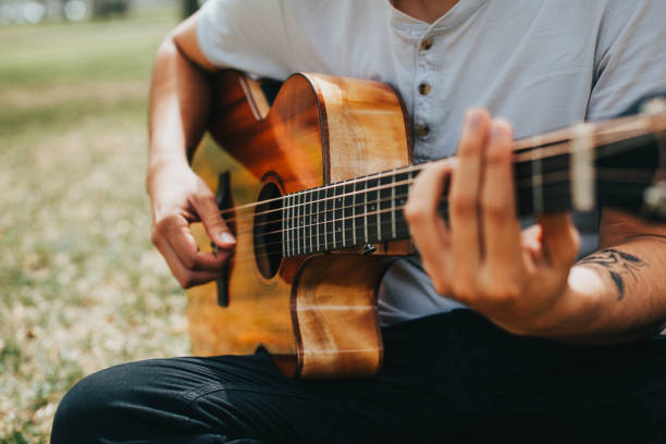 istock Young man playing acoustic guitar outdoors. 1543024925