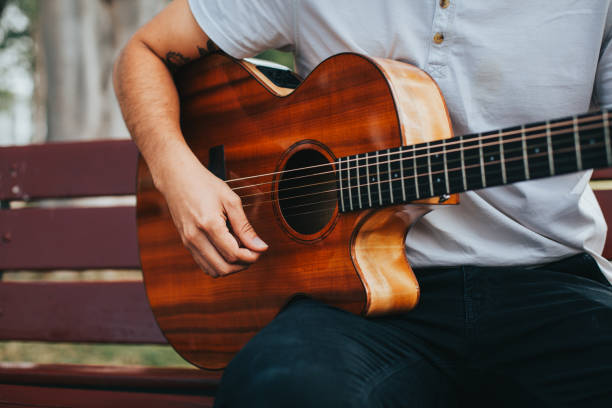 istock Young man playing acoustic guitar outdoors. 1543041417