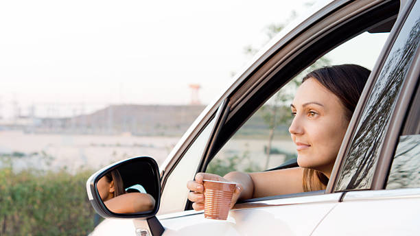 istock Woman sitting in car with a drink 154304446
