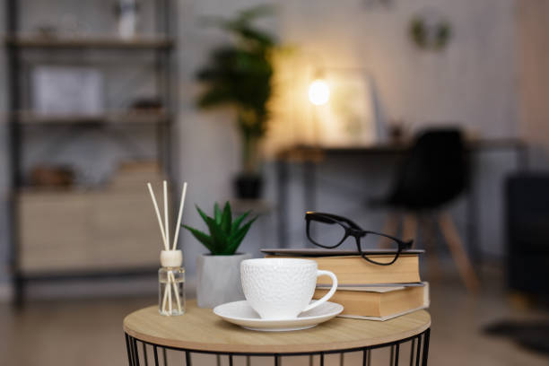 istock reed diffuser, cup of tea or coffee and books on table in living room 1543051405