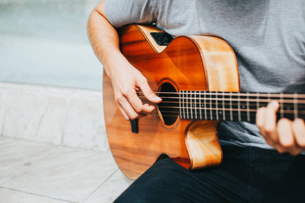 istock Young man playing acoustic guitar outdoors. 1543053543