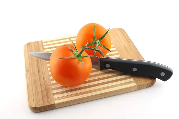 Kitchen-knife and red tomatoes on the preparation board