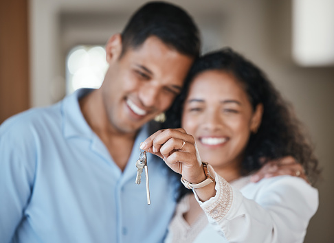 House keys, new home or happy couple hug in real estate, property investment or buying an apartment. Blurred, love or Indian man hugging an excited woman to celebrate goals or moving in together