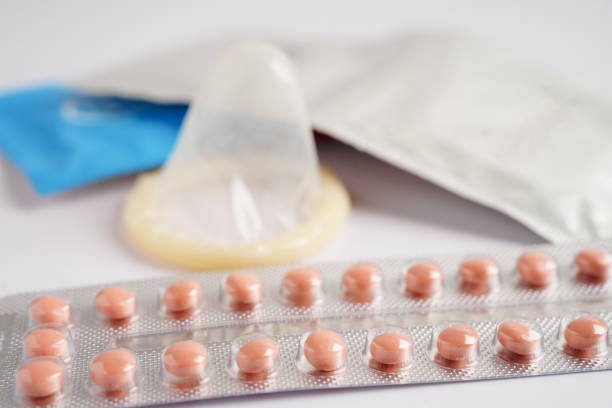 préservatif et pilules contraceptives pour prévenir l’infection, les rapports sexuels protégés et le contrôle des naissances. - contraceptive sex education birth control pill condom photos et images de collection