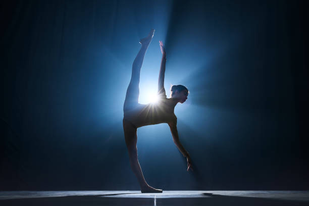 istock Expressive, artistic young woman, professional ballerina making creative performance against dark blue background with spotlight 1543088796